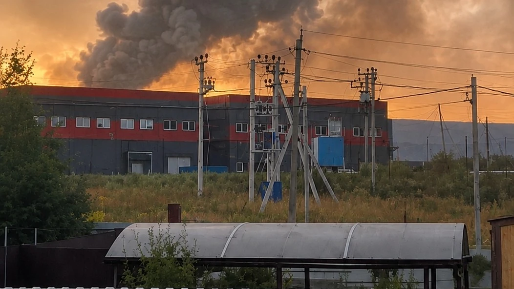 Пожежа та стовп диму над складським комплексом після удару безпілотника